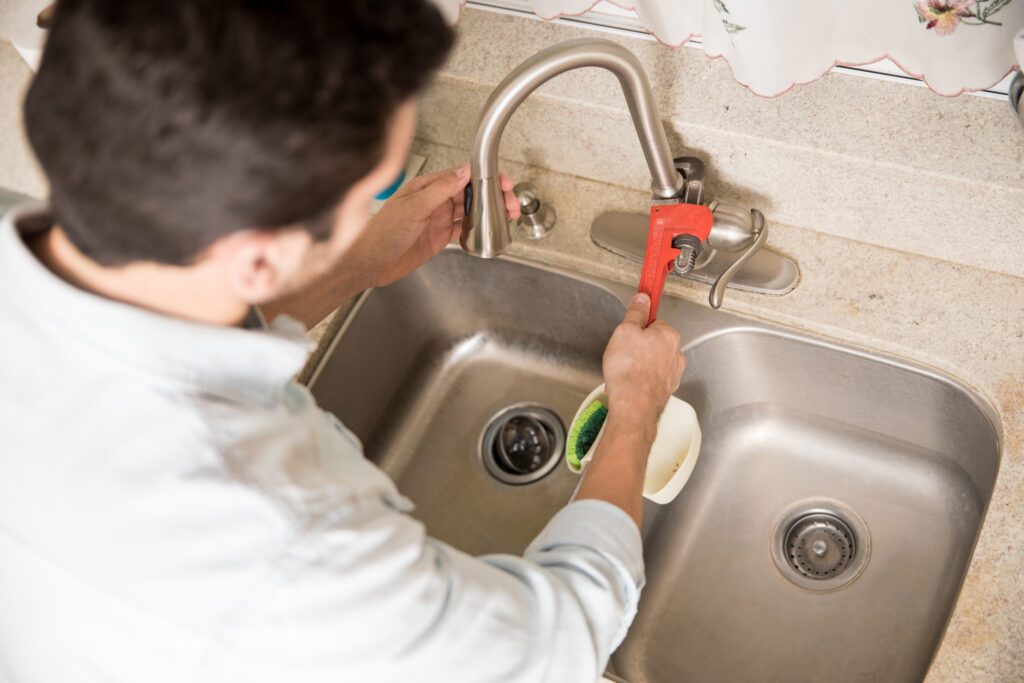closeup of plumber fixing a faucet